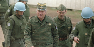 FILE - This is a  April 12, 1993 file photo of Bosnian Serb army Gen. Ratko Mladic, second from left, accompanied by an aide, and French U.N. security troops arrive at a U.N. sponsored meeting at Sarajevo's airport.  Mladic, Europe's most wanted war crimes fugitive, has been arrested in Serbia, the country's president said Thursday, May 26, 2011. Mladic has been on the run since 1995 when he was indicted by the U.N. war crimes tribunal in The Hague, Netherlands, for genocide in the slaughter of some 8,000 Bosnian Muslims in Srebrenica and other crimes committed by his troops during Bosnia's 1992-95 war.   (AP Photo/Michael Stravato)