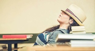 Female teenager student sleeping in classroom