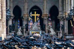 L'interno di Notre Dame con la croce intatta tra le travi bruciate del tetto della cattedrale